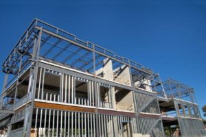 Steel-framed building under construction with a clear blue sky in the background