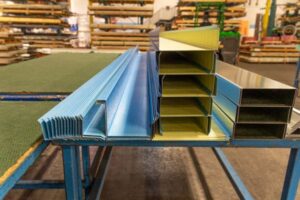 Metal profiles and steel sheets organized on a workbench in a warehouse. 