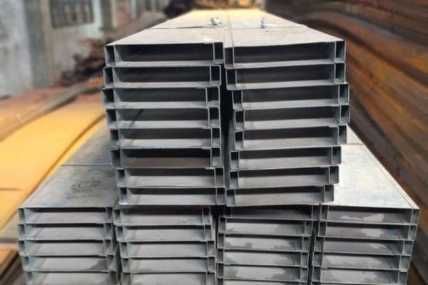 Stacked steel rectangular hollow sections in a warehouse.