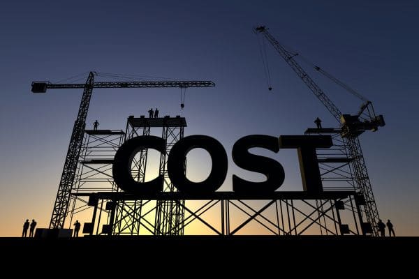 Construction site with large 3D text 'COST' under scaffolding and cranes.