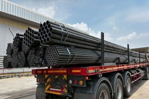 Steel pipes loaded on a red flatbed trailer