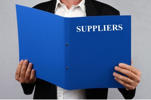 Person holding a blue folder labeled "SUPPLIERS"