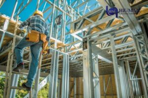 Construction worker on ladder assembling steel frame