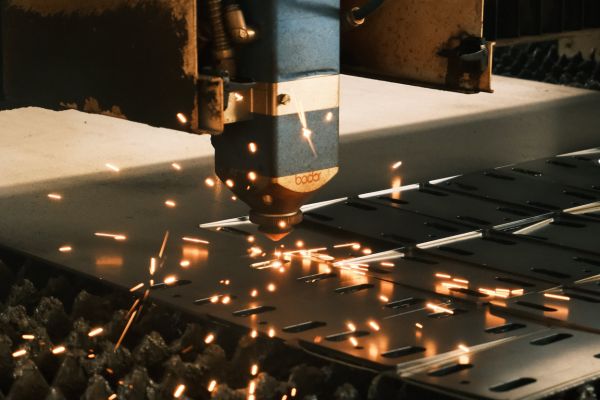 A metal cutting machine produces sparks as it slices through metal, showcasing industrial precision and power.