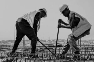 Construction workers installing rebar for reinforced concrete slab