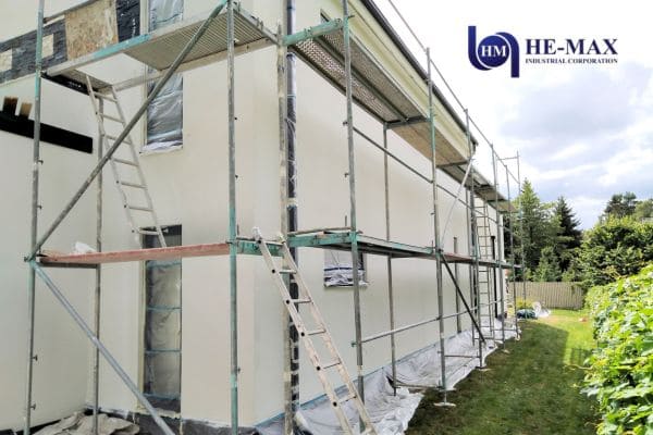 Residential house exterior covered with scaffolding during renovation work.