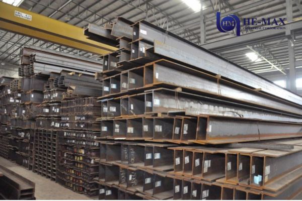 Structural steel H-beams and I-beams stacked in a warehouse for commercial, industrial, and infrastructure construction projects.