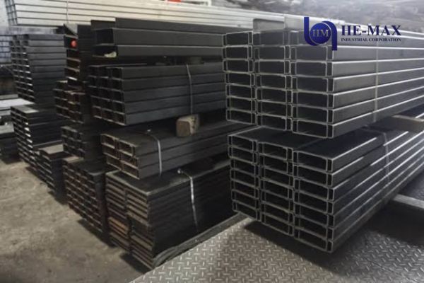Steel C-purlins stacked in a warehouse, showcasing various sizes and lengths for construction use.